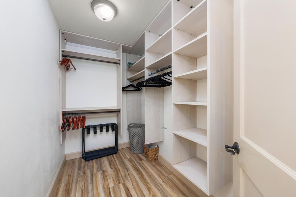 You'll appreciate this spacious walk-in closet with custom shelving, dual hanging rods, and ample storage for all your belongings during your stay.
