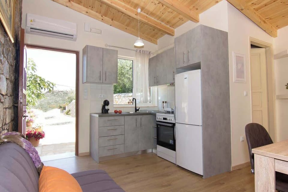 Large openings connect the kitchen with the outdoor spaces, bringing natural light and views into the apartment throughout the day.