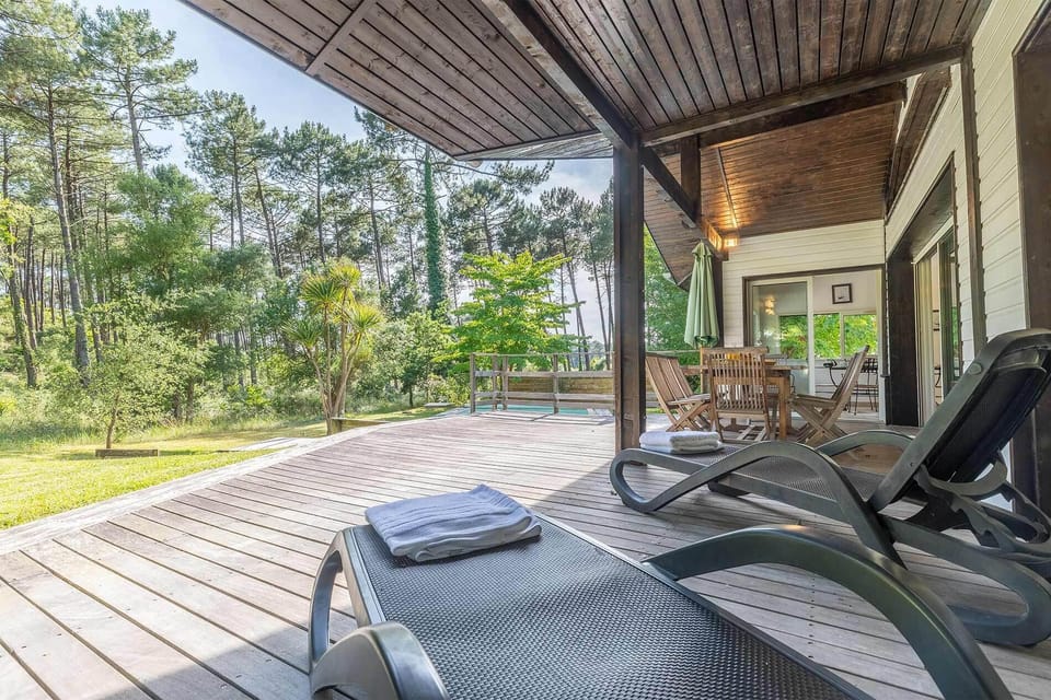 Sun loungers on the deck, pine trees all around — your private corner of the Landes forest.