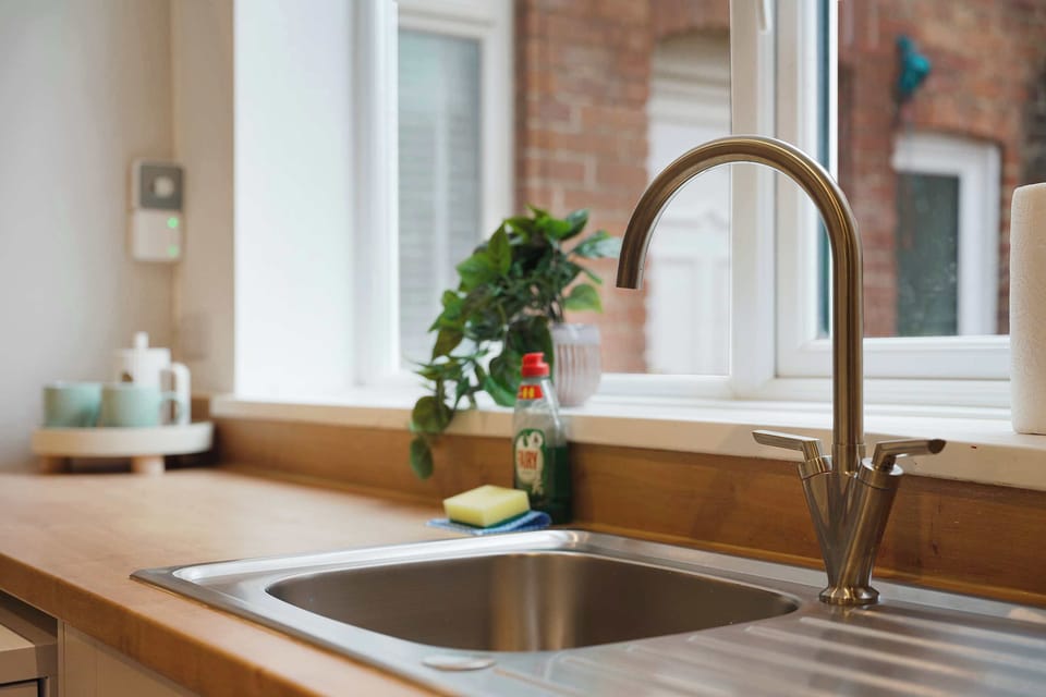 A practical kitchen setup featuring a large sink, sleek worktops, and everyday essentials arranged for easy meal preparation. With plenty of usable counter space, it offers a comfortable setup for cooking throughout your stay.