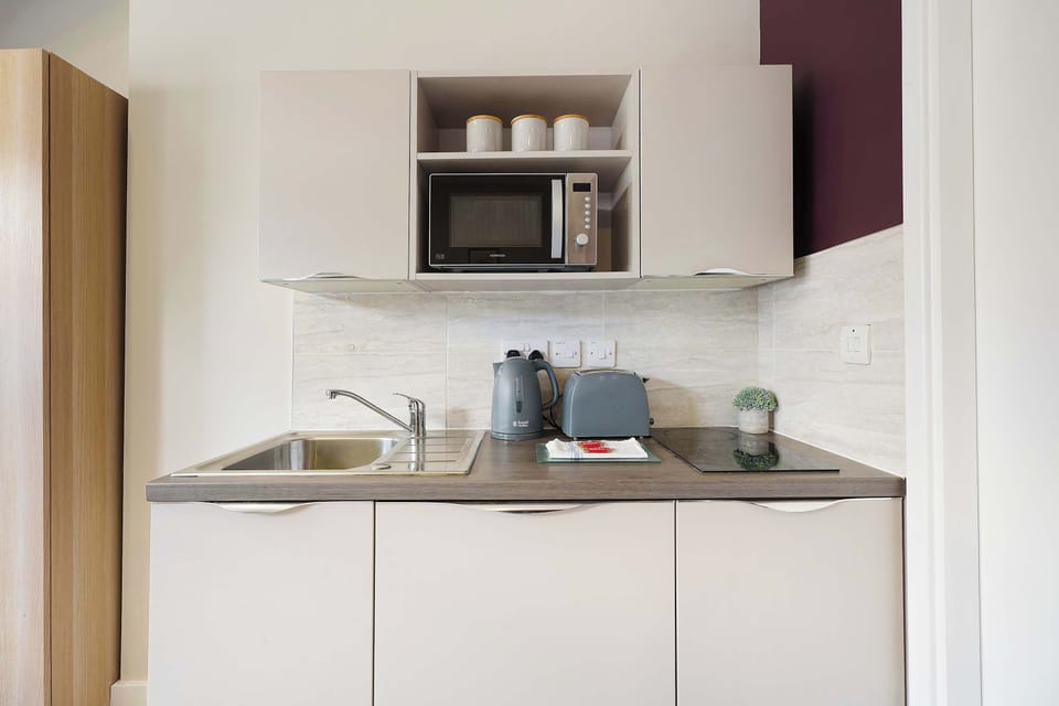 Within the studio, the practical kitchenette is fully equipped with a stove, microwave, kettle, cookware, crockery, and utensils. It provides everything needed for a simple self-catering stay, from breakfast to light evening meals.