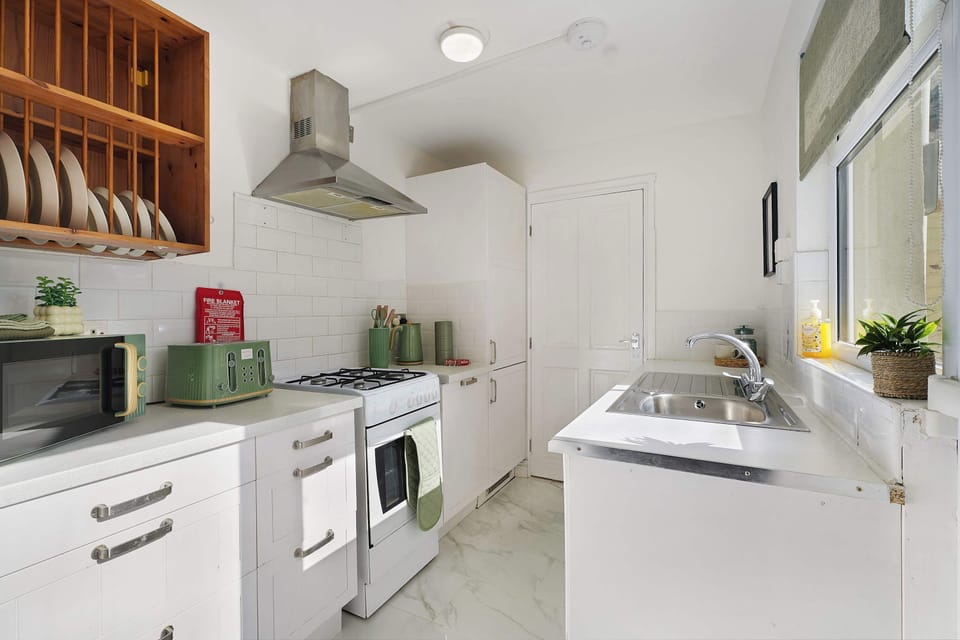 Functional kitchen space featuring essential appliances including an oven, hob, fridge freezer, and washing machine. A convenient layout provides everything needed for a comfortable self-catering stay.