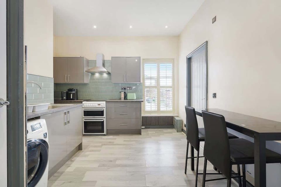 This functional kitchen is equipped for everyday convenience, offering a fridge freezer, oven, microwave, air fryer, sink, and washing machine. Ideal for preparing simple meals, snacks, or keeping up with laundry during your visit.