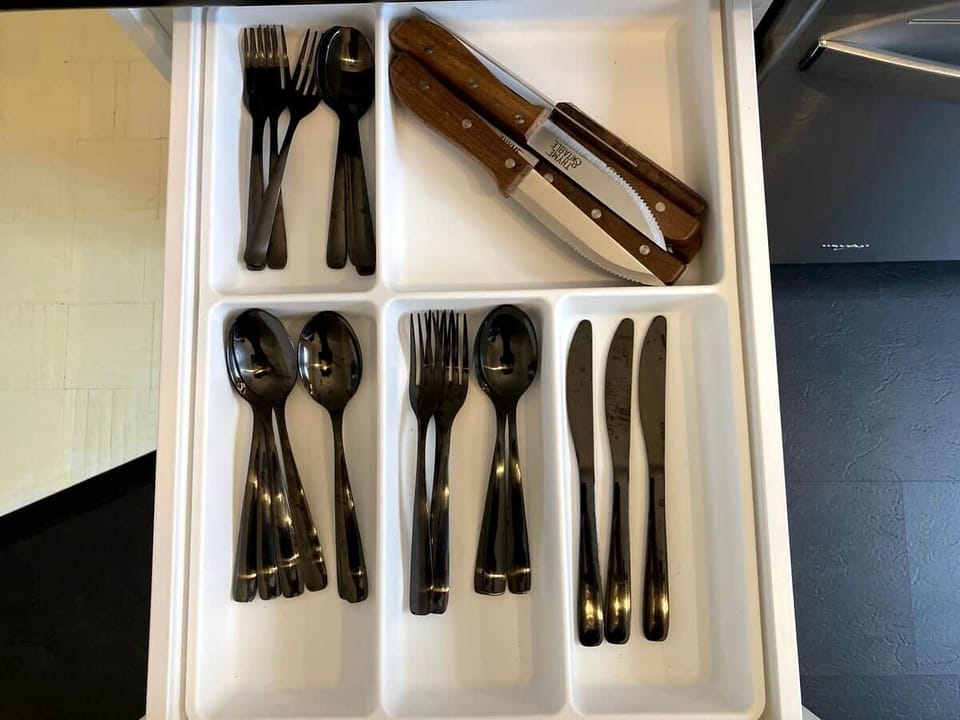 Fully equipped kitchen with modern appliances, spices, quality knives, cookware, and dishwasher. Ideal for cooking, coffee, or casual dining in a sleek, organized space that opens to the dining area—perfect for foodies and families alike.