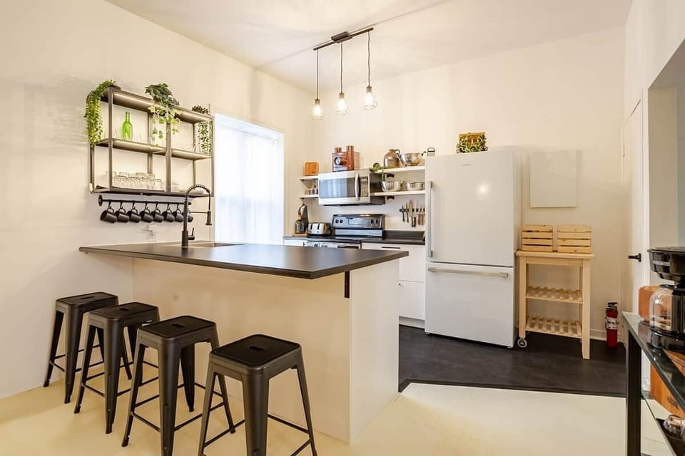 Fully equipped kitchen with modern appliances, spices, quality knives, cookware, and dishwasher. Ideal for cooking, coffee, or casual dining in a sleek, organized space that opens to the dining area—perfect for foodies and families alike.
