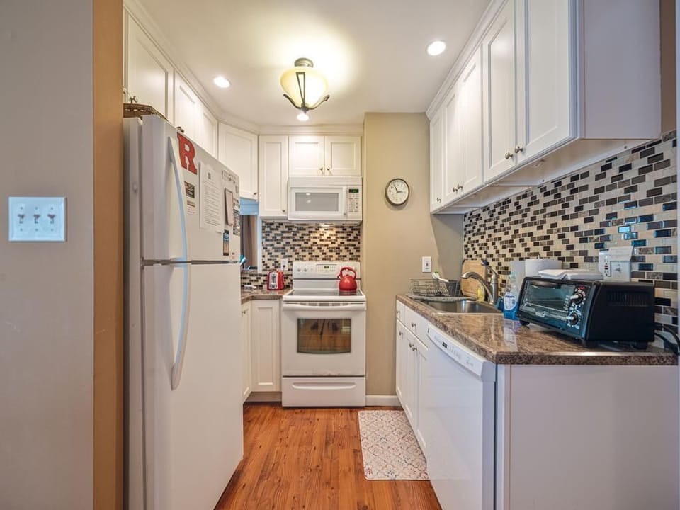 Cook your favorite meals in this bright, fully equipped kitchen featuring modern appliances and stylish accents.