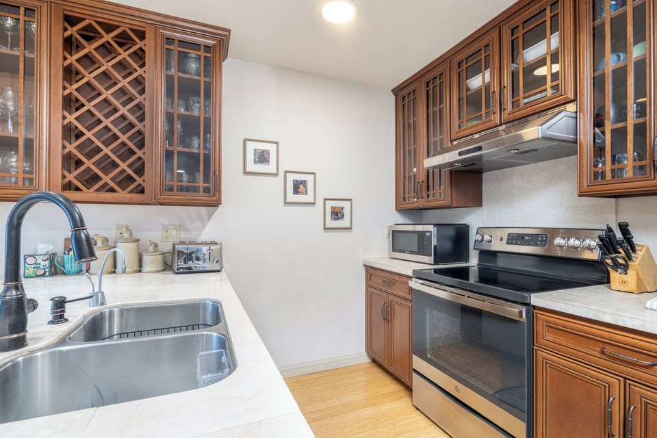 Your fully equipped kitchen features elegant wood cabinetry, marble-style countertops, and all the modern appliances you need to create memorable meals during your stay.