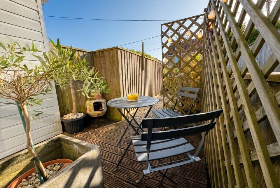 Sun-drenched private deck with bistro seating and a chiminea for cosy evenings.