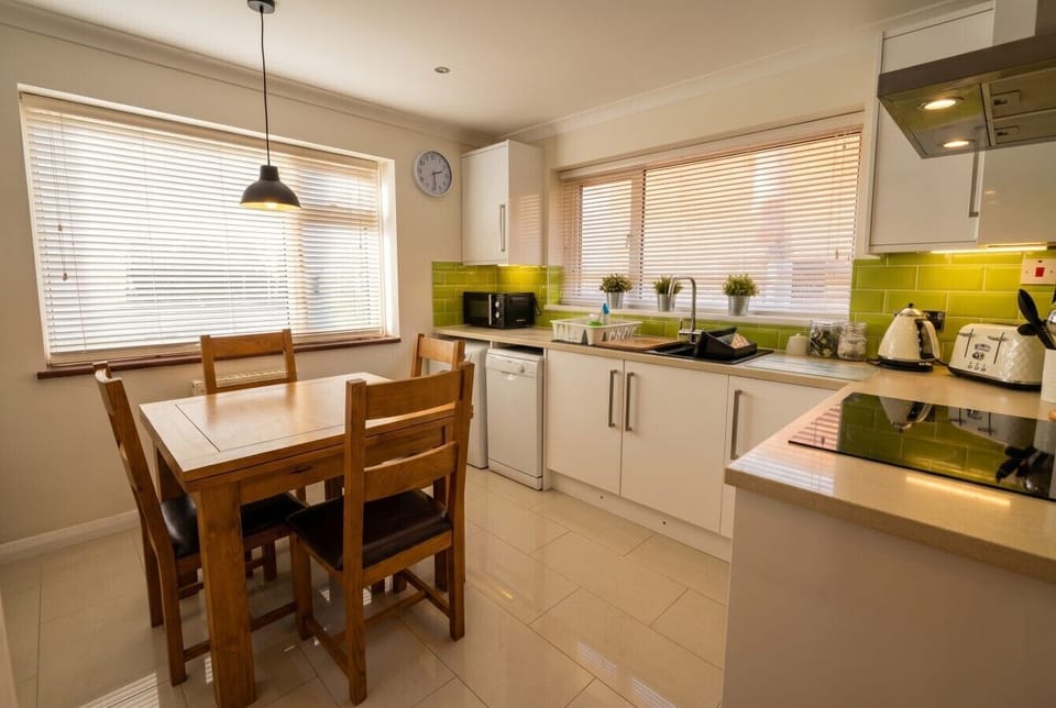 Sunlit kitchen and dining nook ready for relaxed seaside breakfasts.