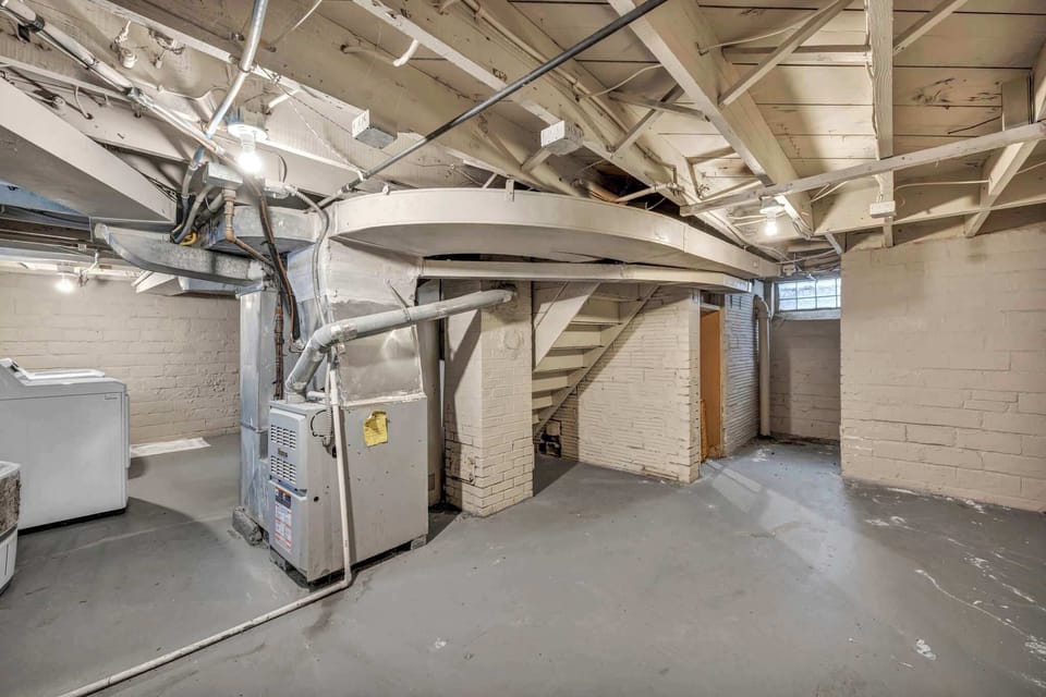 Spacious laundry & utility area w/ exposed brick walls & plenty of room to move.
