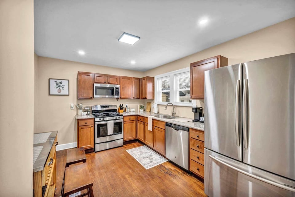 Spacious kitchen w/ stainless steel appliances & warm wood cabinetry.
