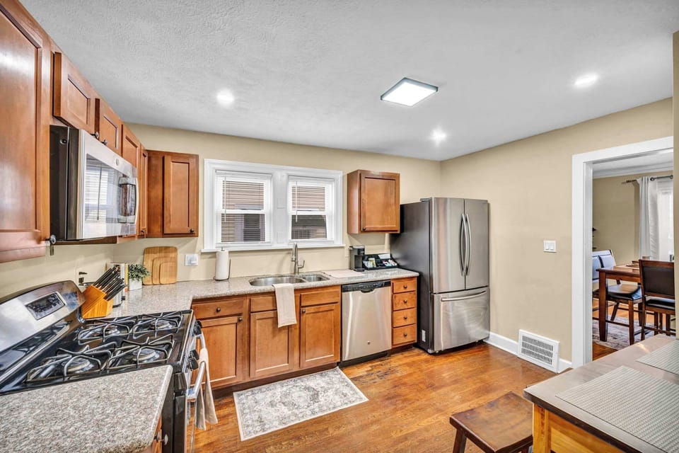 Open-concept kitchen view w/ wood cabinets, stainless appliances & easy flow to dining.
