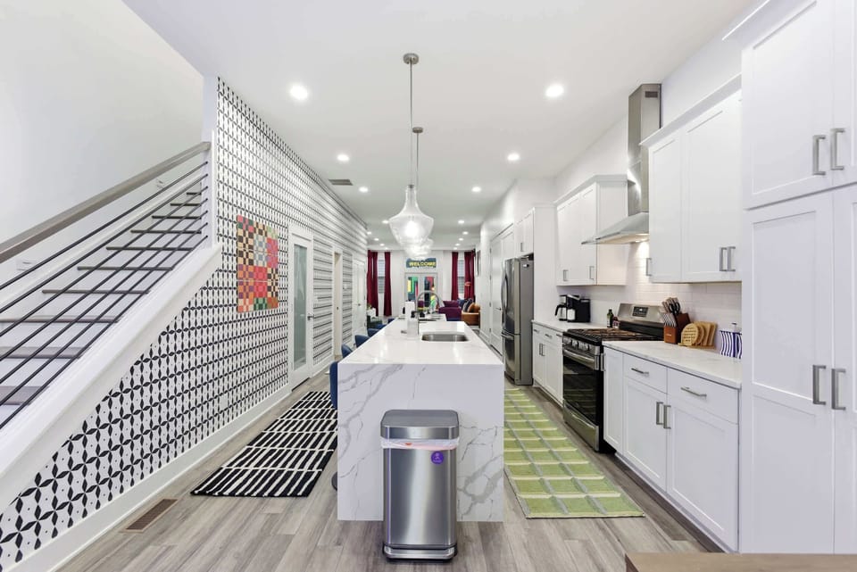 A bright, fully equipped kitchen with a marble island, stainless appliances, and room for the whole crew to cook together.