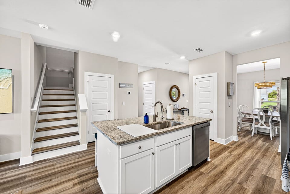 Your open-concept living space invites you to unwind with its bright, airy design. The modern kitchen island features granite countertops and stainless appliances, perfect for preparing meals while mingling.
