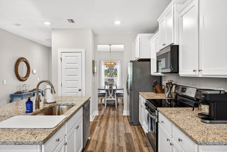 Your bright, fully-equipped kitchen features granite counters, stainless appliances, and everything you need to prepare meals at home. Modern white cabinetry provides plenty of storage for your vacation staples.