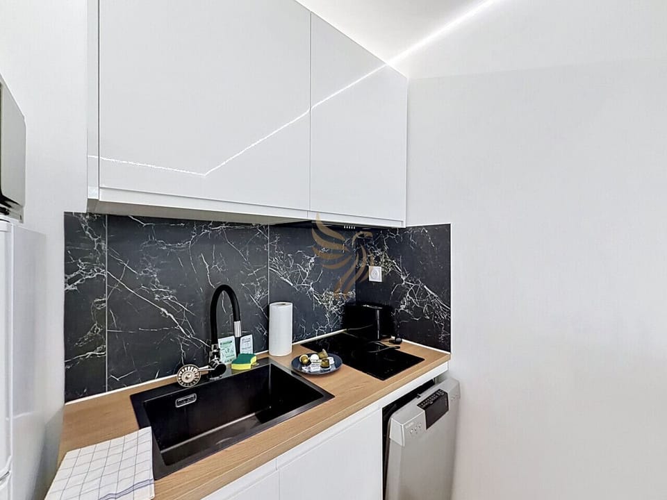 Commencez la journée ici : préparez un café sur la machine à côté de la plaque à induction, sous la crédence marbre qui réchauffe l`espace. Un coin cuisine fonctionnel et cosy pour des matins sereins.