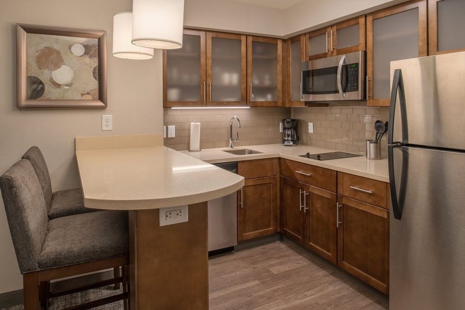 Kitchen with modern appliances, cabinetry, and bar seating.