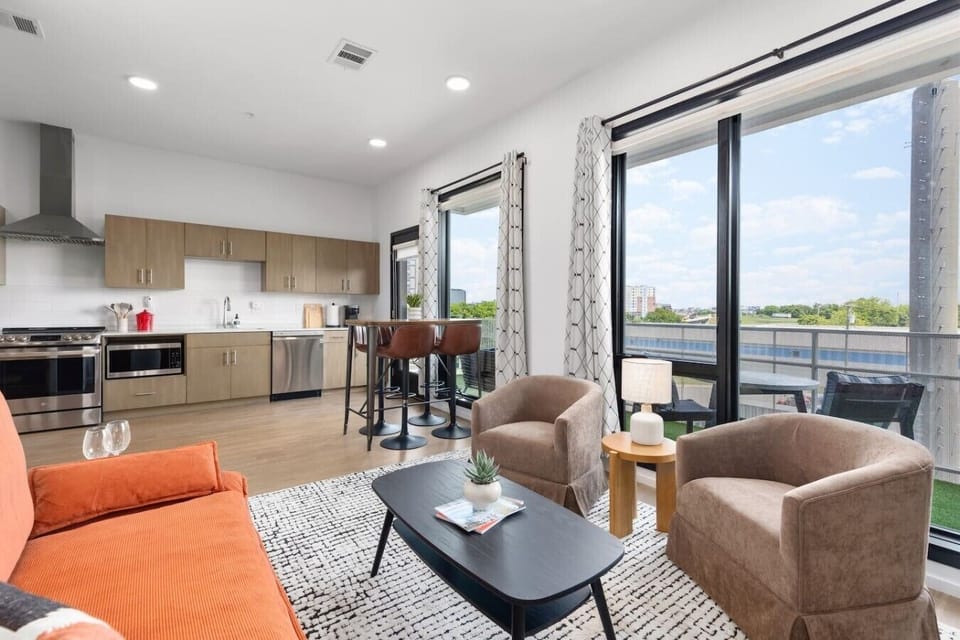 Comfortable living room with a Smart TV, pull-out couch, and lots of natural light attached to the private balcony.