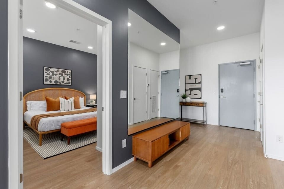 Entryway with the large mirror, leading into the bedroom with a comfortable King bed, closet, smart TV and ensuite bathroom (accessible from the bedroom and the entryway).