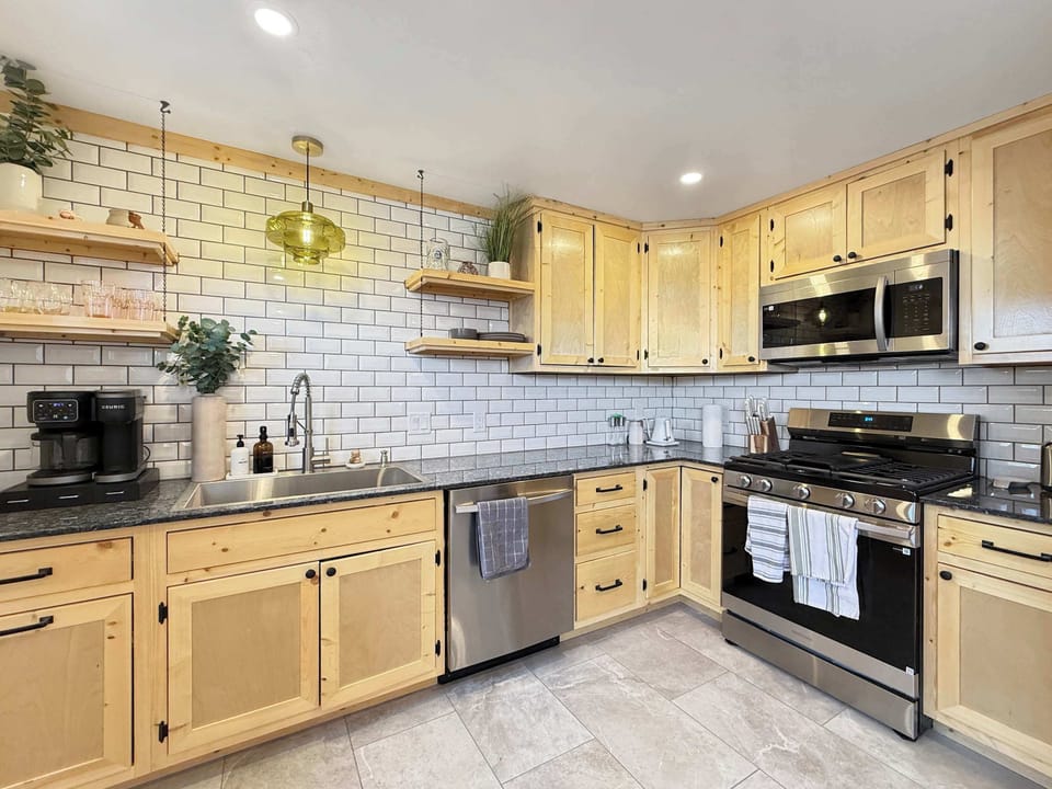 【Kitchen Detail】 Subway tile, butcher-block shelving, gas range — built for actual cooking