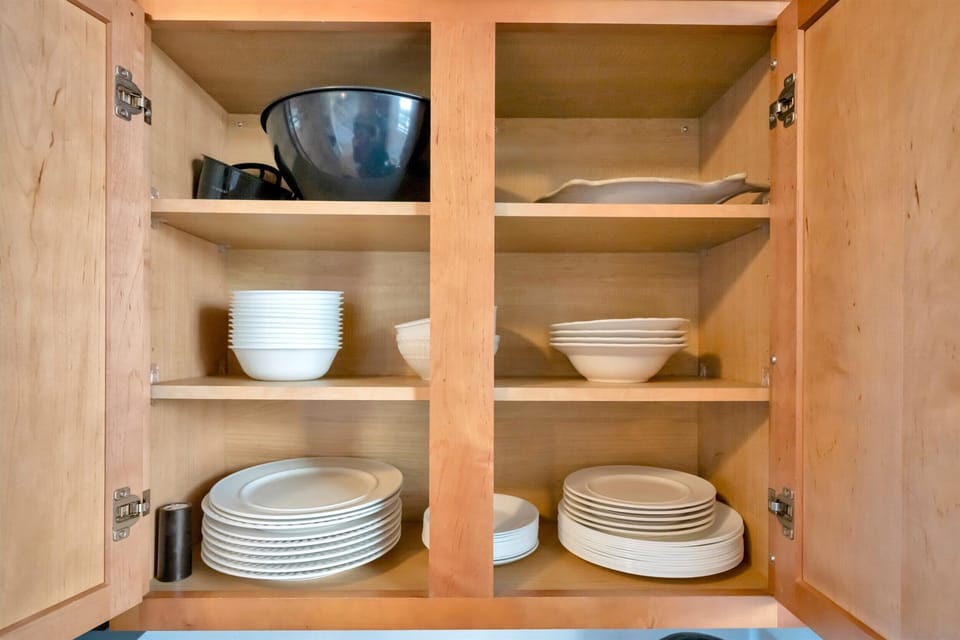 Kitchen cabinet stocked with dishes and bowls