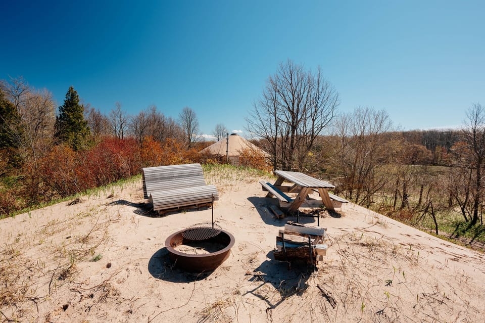 Relax atop the dunes with lounge seating, a picnic table, and a private fire pit overlooking the water and surrounding landscape.