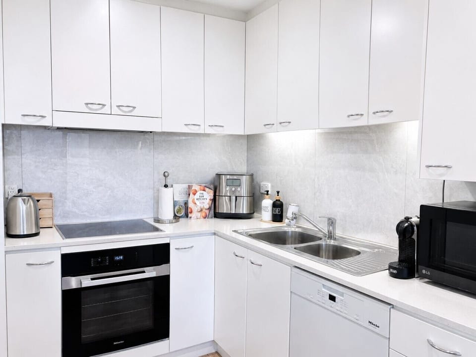 Modern kitchen with premium Miele appliances, stone benchtops, coffee machine, air fryer, dishwasher and all the essentials for a comfortable stay