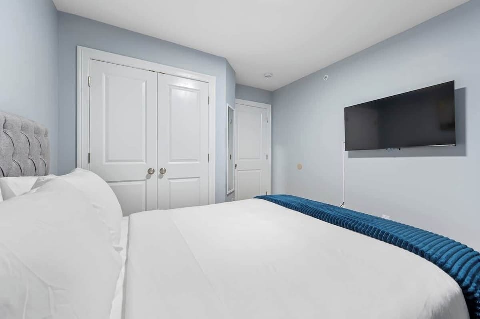 Cozy bedroom featuring a queen bed, soft linens, and ample natural light. Comfortable and inviting, perfect for restful nights and relaxation.