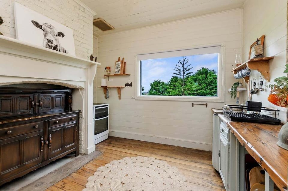 Rustic kitchen with large window and classic stove.