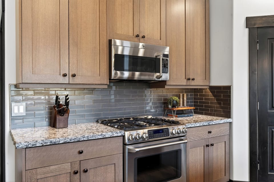 Gourmet kitchen detail featuring stainless steel appliances and a modern subway tile backsplash.
