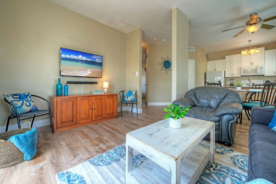 Open living area with coastal accents, balcony access, and a queen pull-out sofa for extra sleeping space.