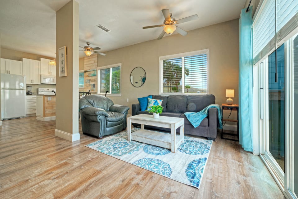 Open living area with coastal accents, balcony access, and a queen pull-out sofa for extra sleeping space.