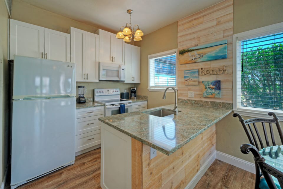 Prepare easy beach-day meals in the bright kitchen with coastal décor, full-size appliances, and island prep space.