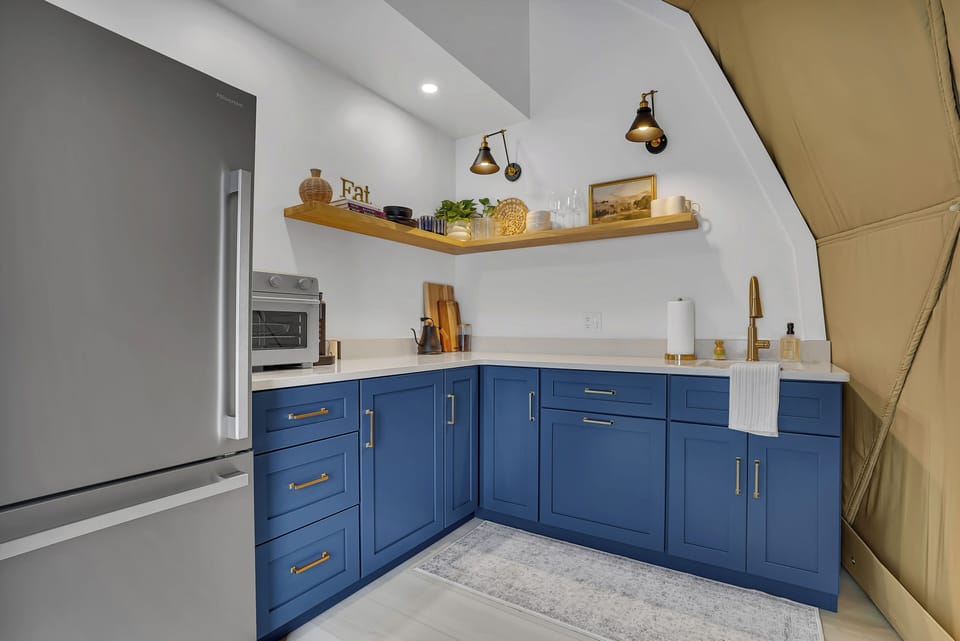 The kitchenette is equipped with essentials like a refrigerator, sink, air fryer/toaster oven, and Keurig coffee maker.
