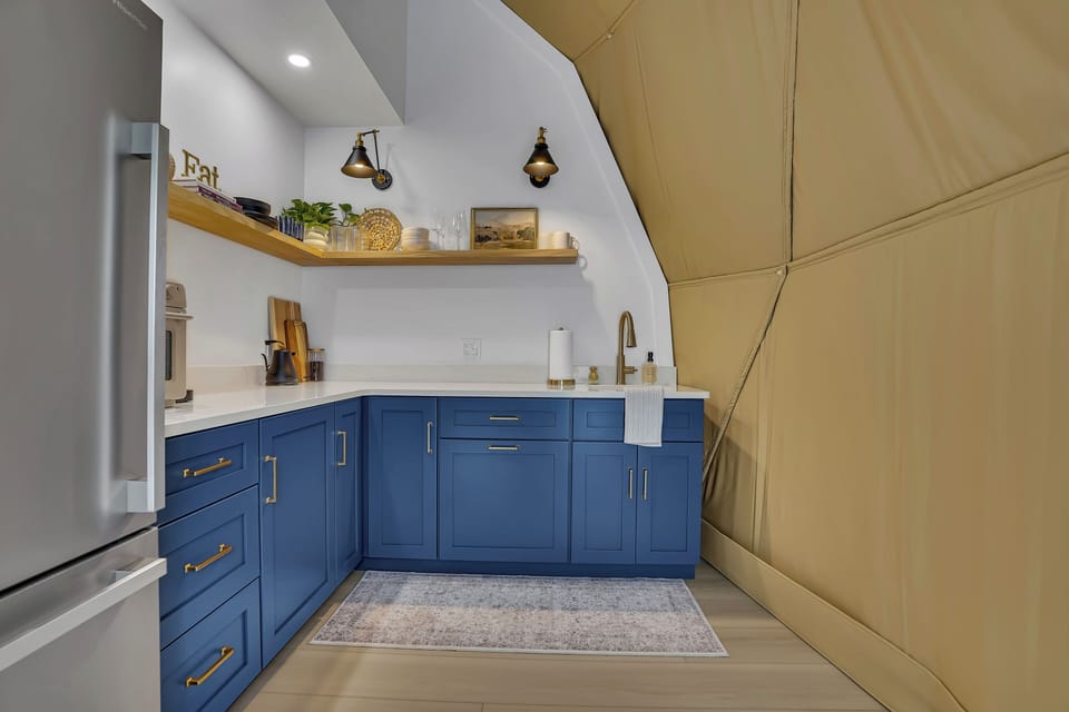 The kitchenette is equipped with essentials like a refrigerator, sink, air fryer/toaster oven, and Keurig coffee maker.