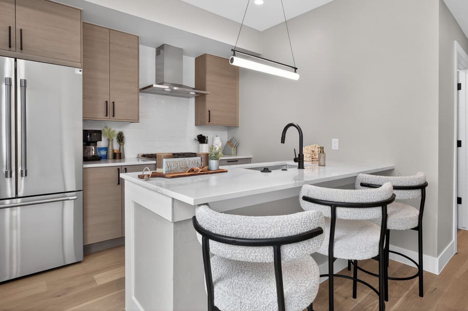 Your sleek modern kitchen awaits with quartz countertops, stainless steel appliances, and cozy breakfast bar seating for memorable morning meals.