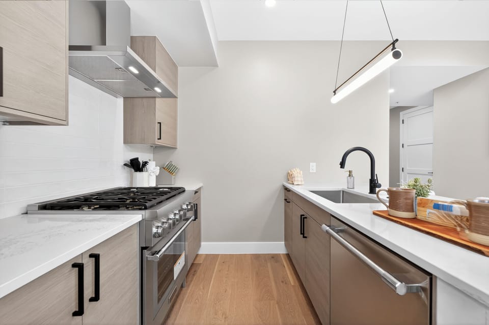 Your sleek galley kitchen features modern appliances, quartz countertops, and warm wood finishes—perfect for preparing memorable meals during your stay.
