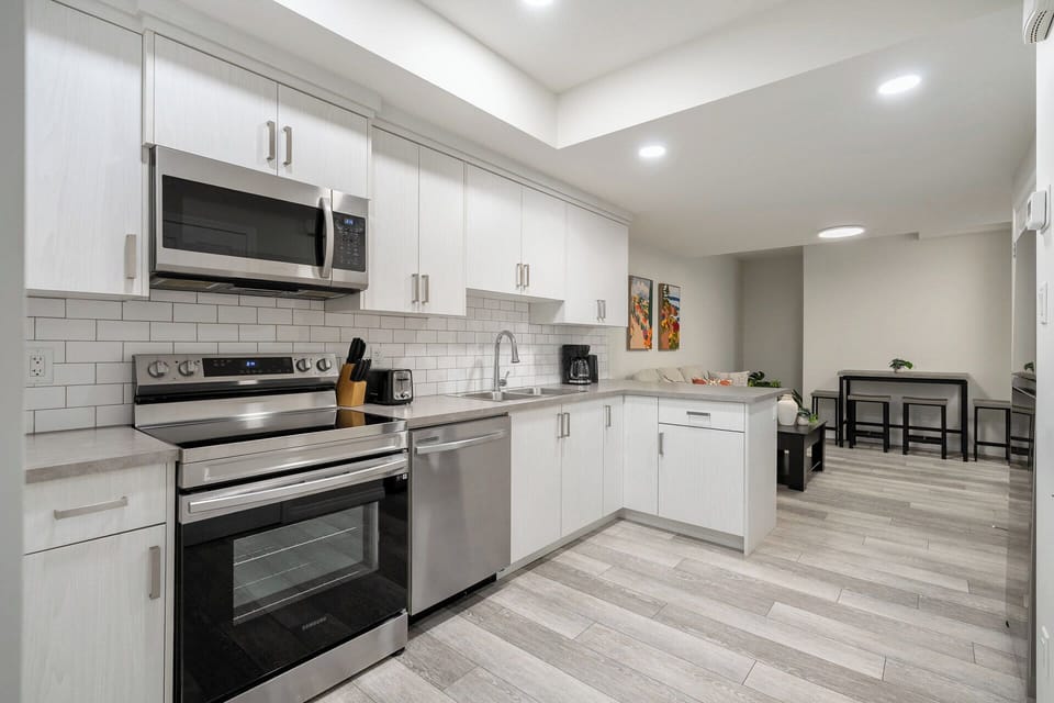 Fully Equipped Modern Kitchen with Stainless Steel Appliances & Dining Table