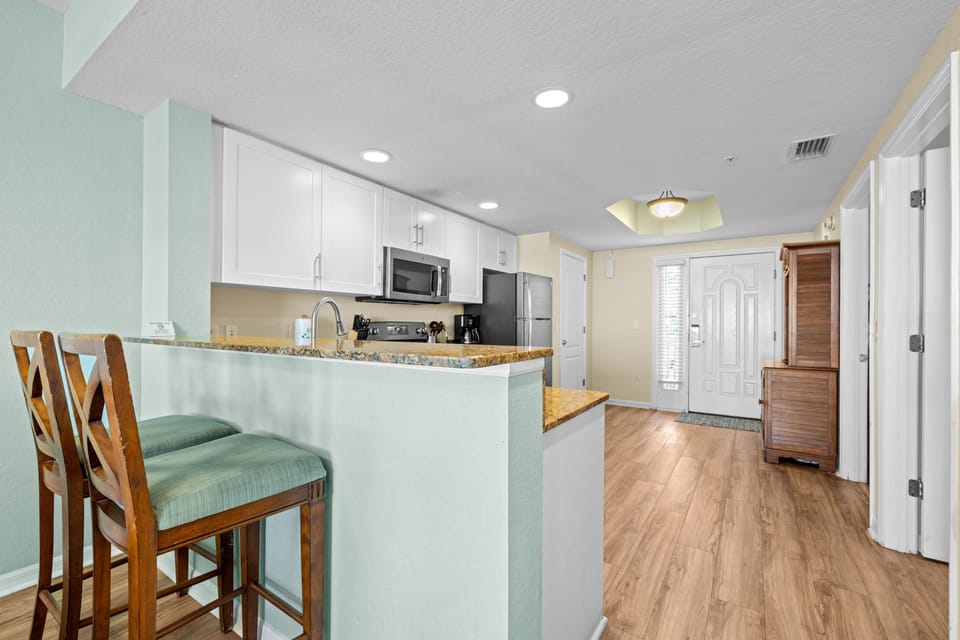 Step into a modern kitchen equipped with full-size appliances and charming breakfast bar.