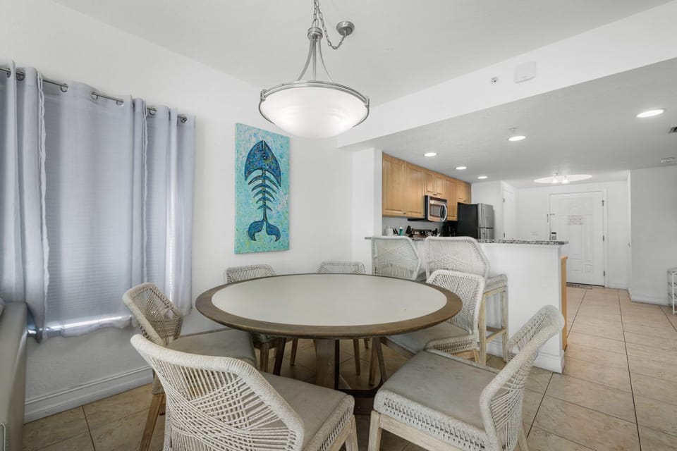 Gather around the stylish dining table and enjoy meals with friends, accented by a vibrant fish painting.