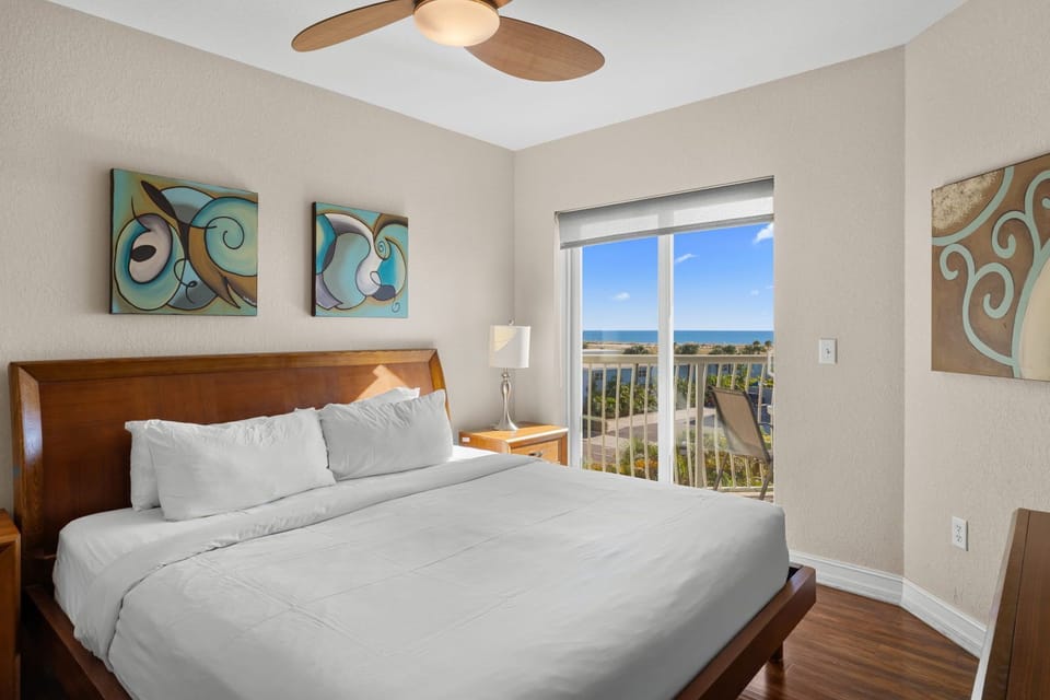 Wake up in the king-bed room with soft white linens, a TV, and direct access to the private balcony.