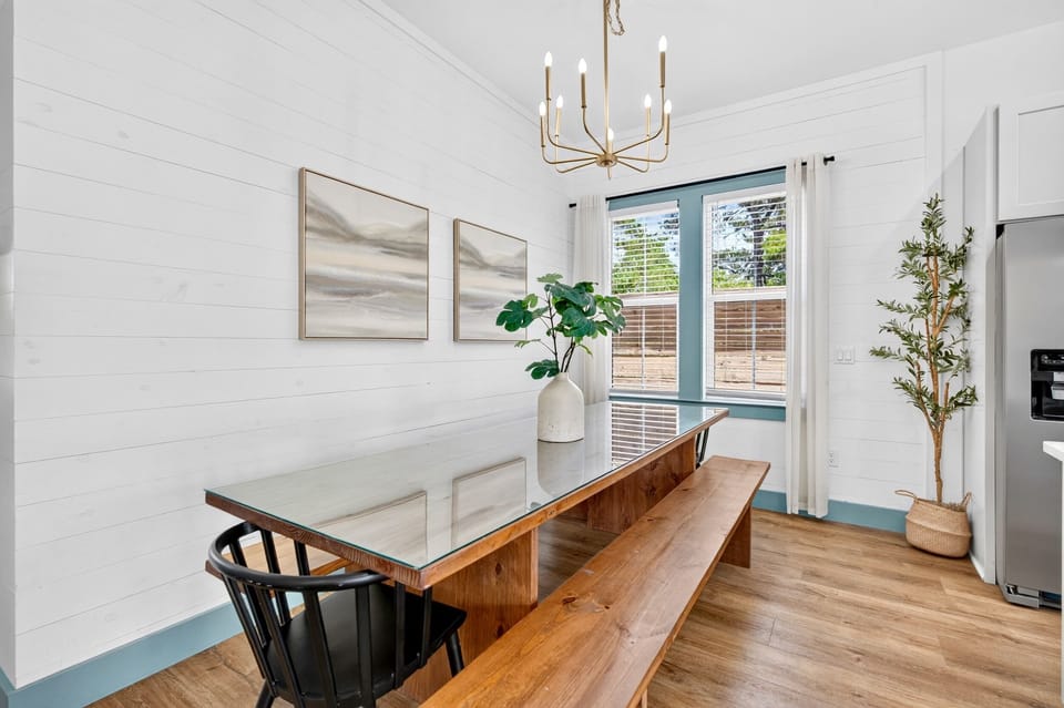 1st floor- Dining area with glass-top farmhouse table and bench seating—seats the whole group comfortably and sits right off the kitchen for easy flow between cooking and eating