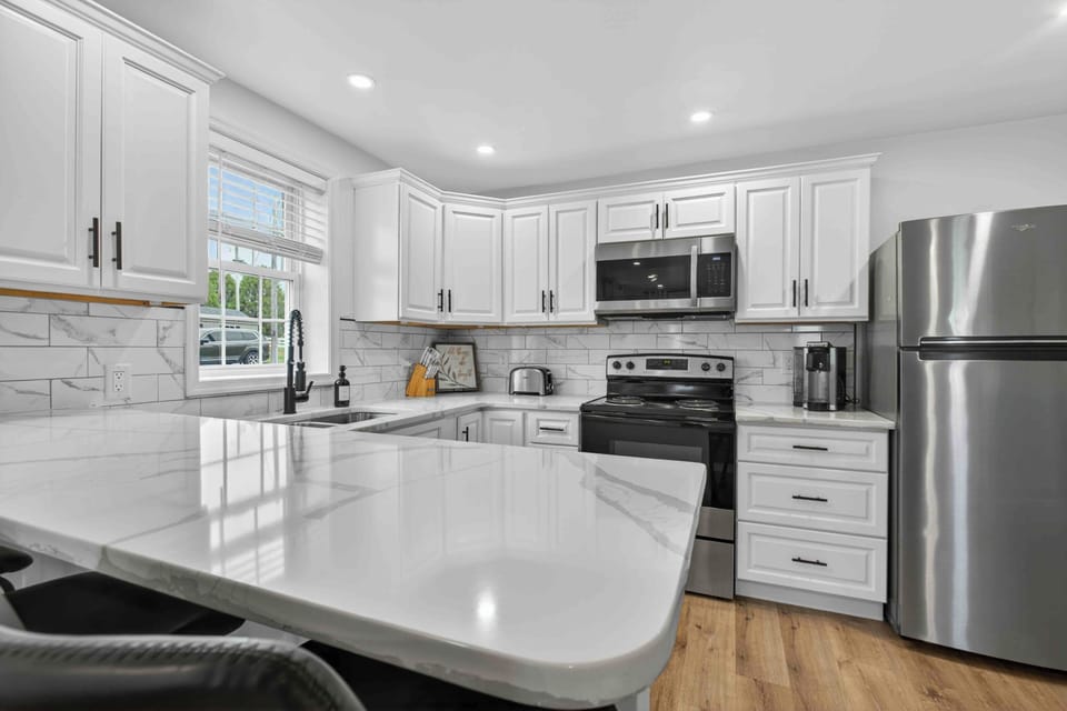 Bright modern kitchen with quartz peninsula & stainless appliances
