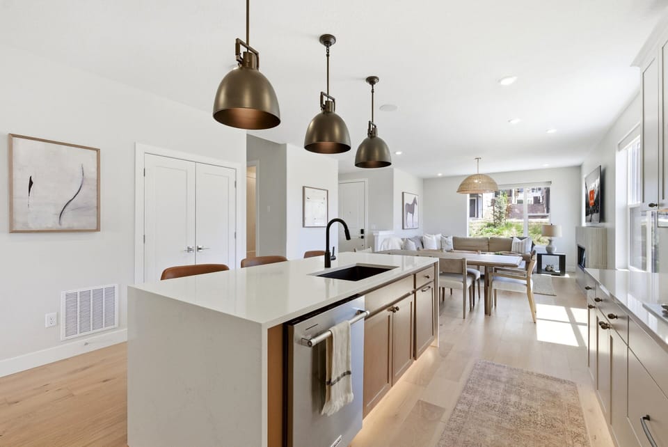 Gourmet kitchen at Moonrise at Coyote Bend with a large island, pendant lighting, and open flow into the dining area.