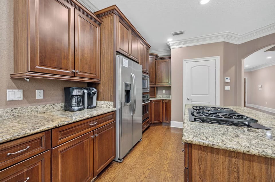 Your gourmet kitchen awaits with rich wood cabinetry, granite countertops, stainless steel appliances, and a gas cooktop perfect for whipping up delicious meals during your stay.