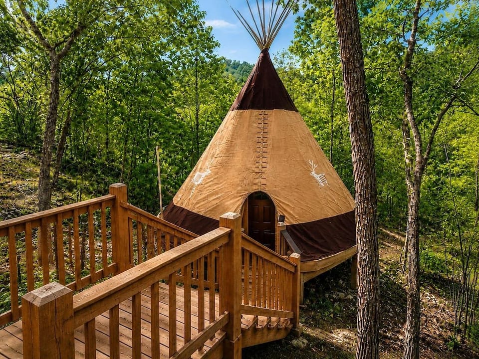 Beautiful daytime perspective of the unique teepee structure nestled in a lush.