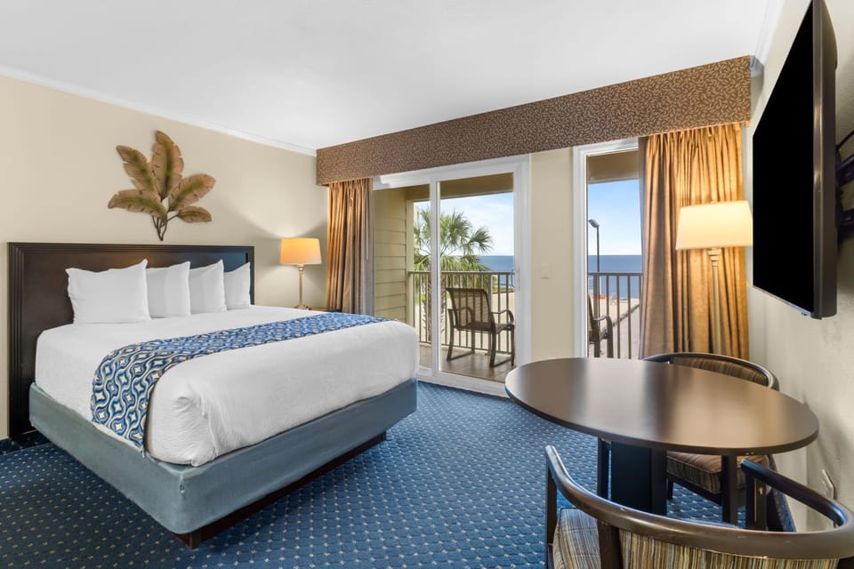 A bright and comfortable suite awaits you, with a view to the balcony and inviting seating.