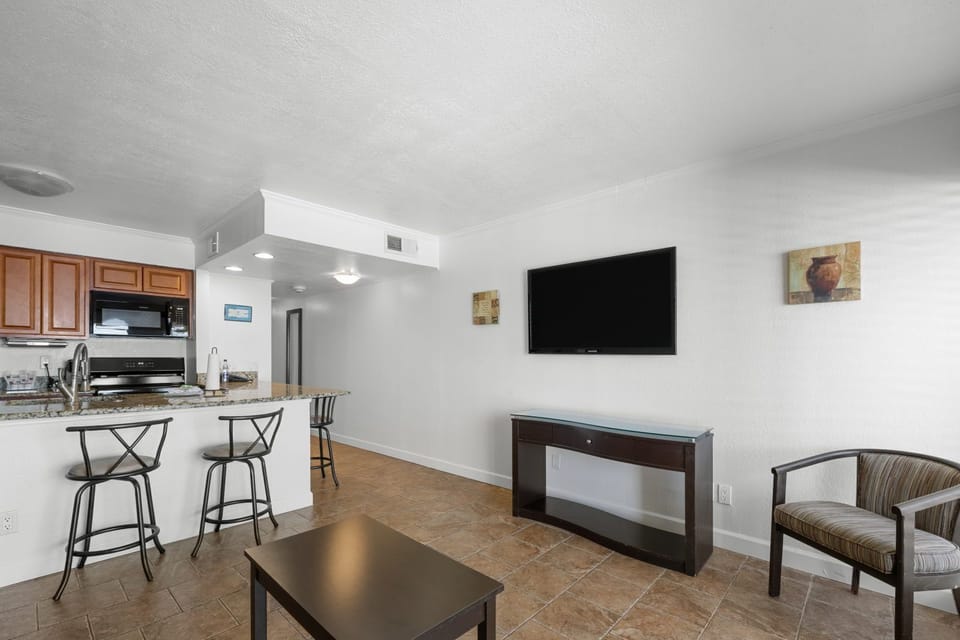 Relax at the breakfast bar, surrounded by warm wood tones and a welcoming kitchen space.