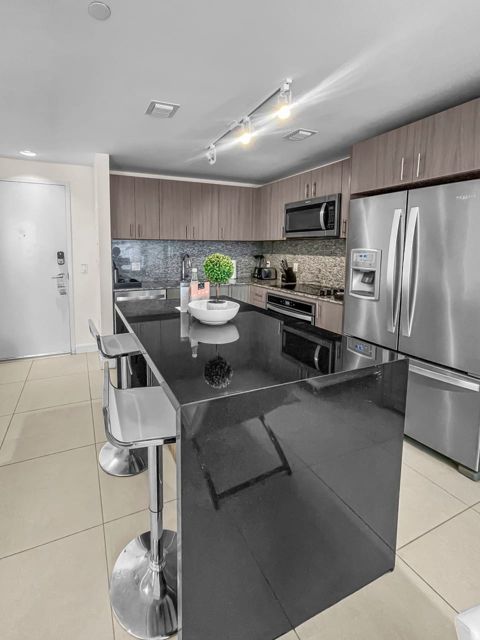Welcome to a culinary haven! Enjoy the elegance of this modern kitchen with a chic breakfast bar.