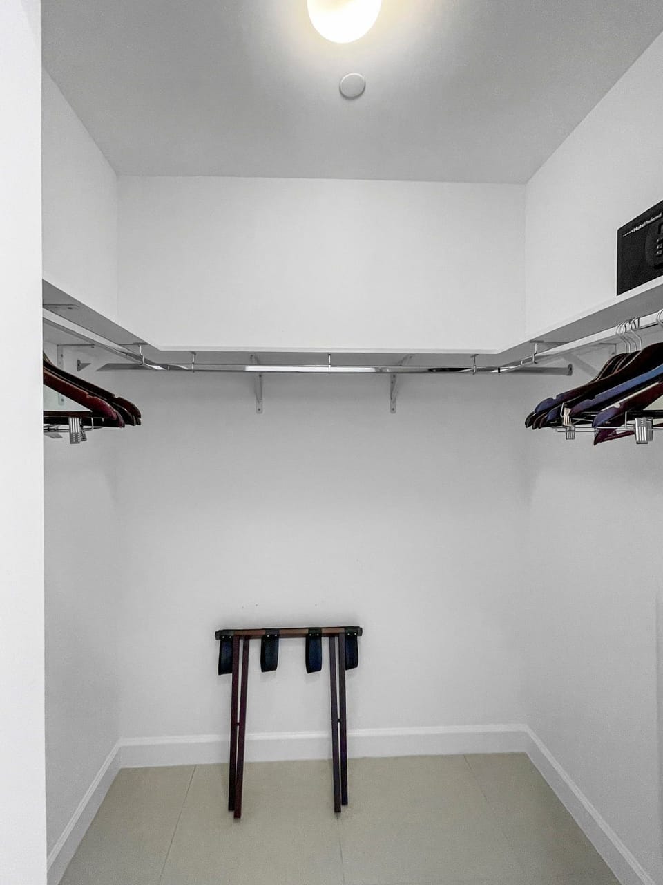 Organize your essentials in this spacious closet, complete with ample hanging space and additional seating.